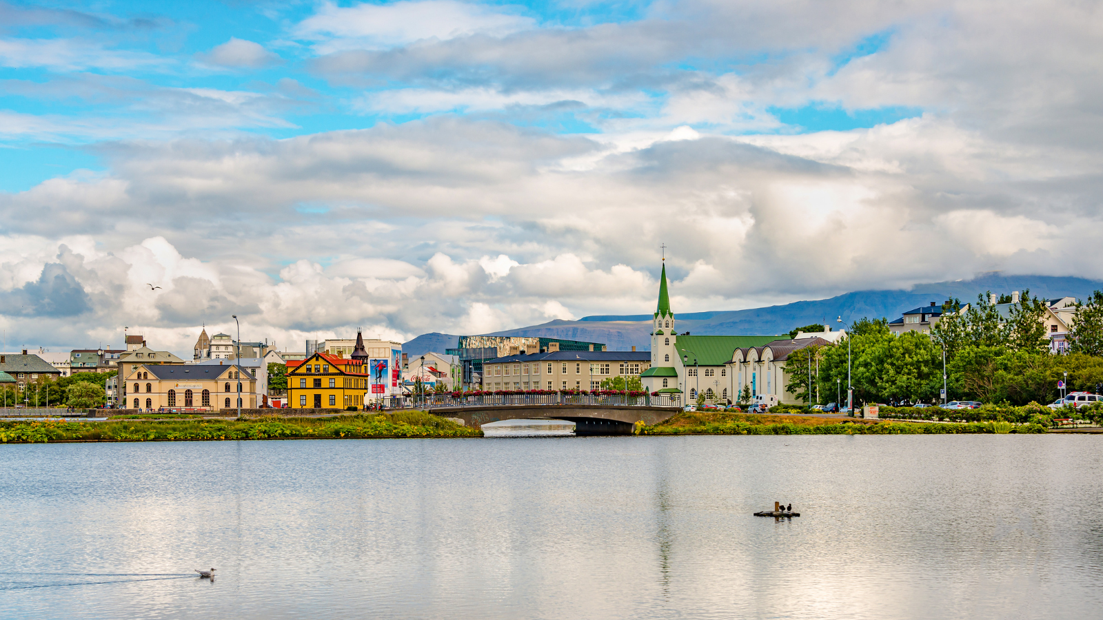 Colourful buildings of downtown Reykjavik with Lake Tjörnin in the foreground.